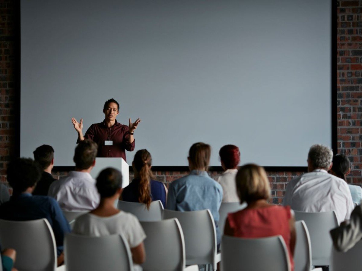 Event - Male speaker in front of a brick wall