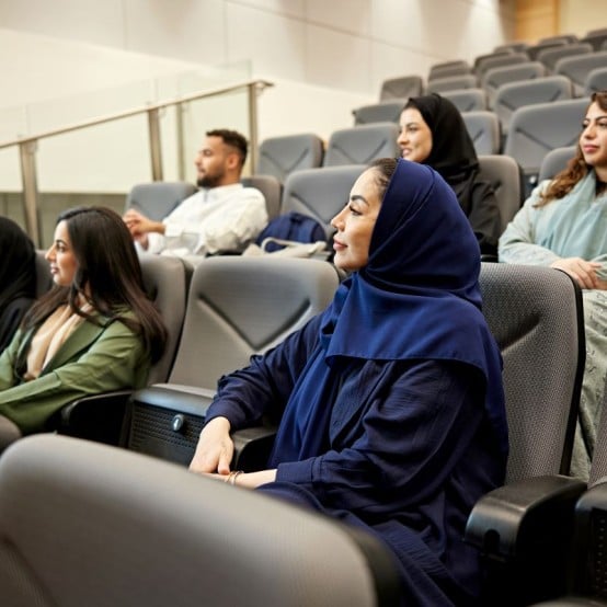 South Asian women attending a lecture in an auditorium