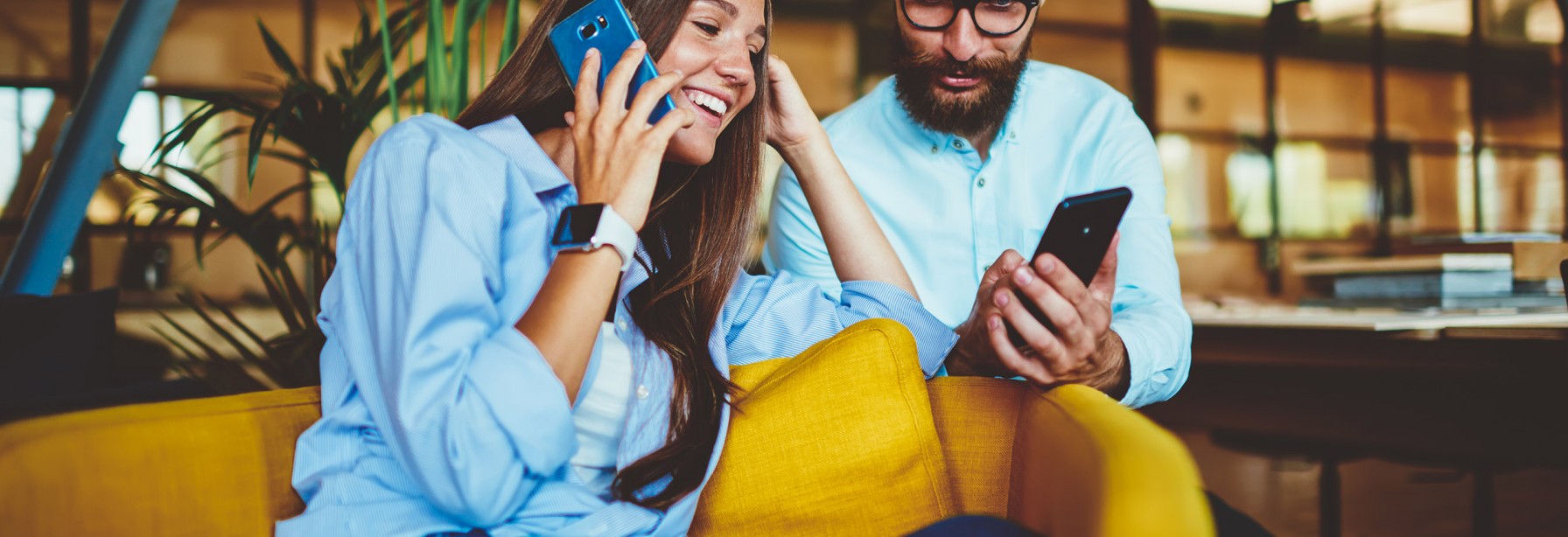 Couple sitting on couch each on their own phones